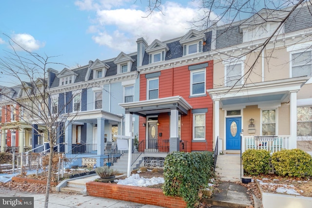 view of property with a residential view and mansard roof