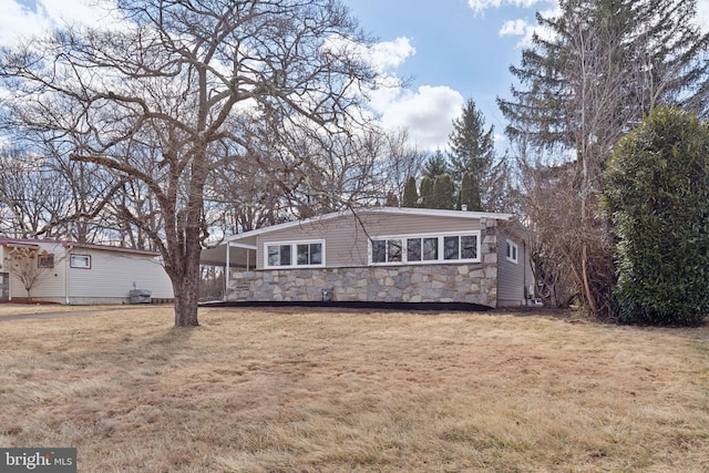 view of front of home featuring stone siding and a front lawn