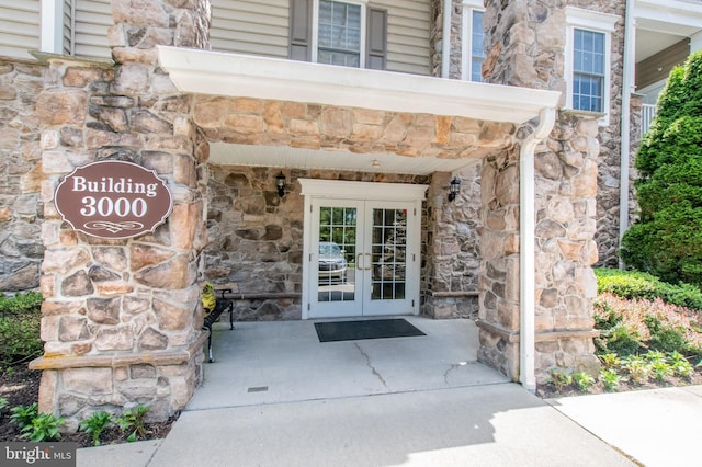 doorway to property with stone siding and french doors