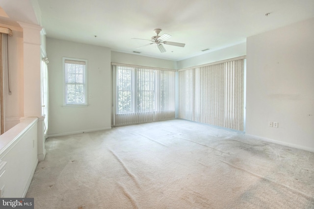 empty room featuring ceiling fan and light colored carpet