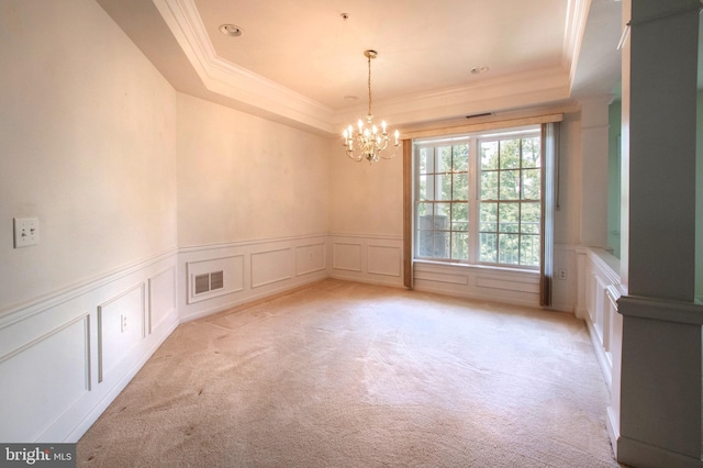 spare room with visible vents, a tray ceiling, and light colored carpet