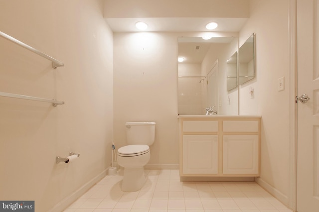 bathroom featuring toilet, tile patterned flooring, baseboards, and vanity