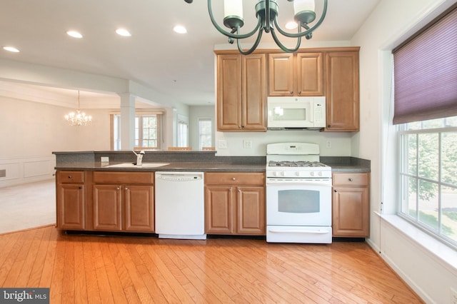 kitchen with white appliances, dark countertops, and a notable chandelier