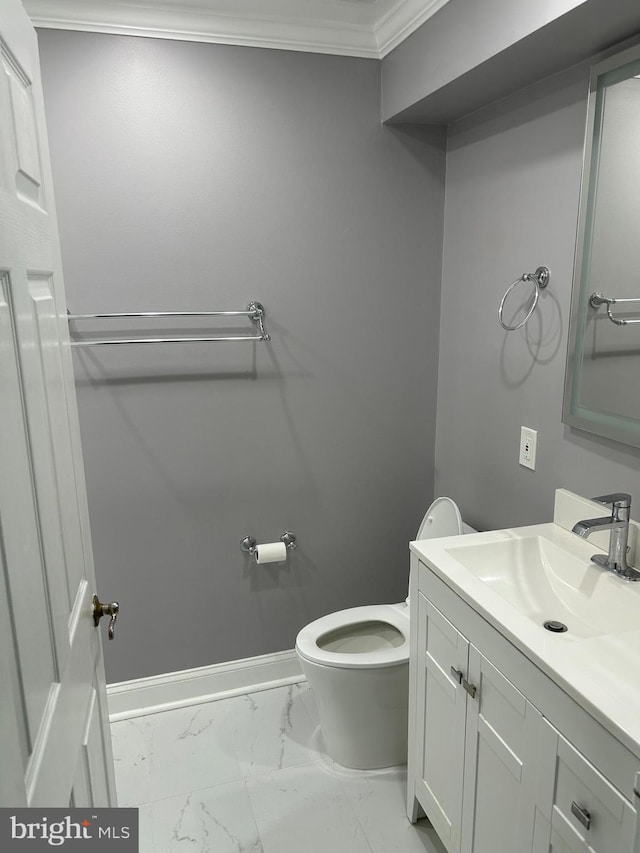 half bath with baseboards, toilet, ornamental molding, marble finish floor, and vanity