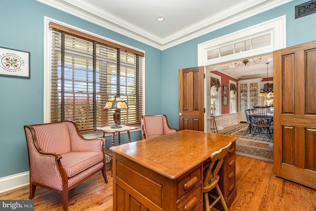 office area featuring baseboards, light wood-style flooring, visible vents, and crown molding