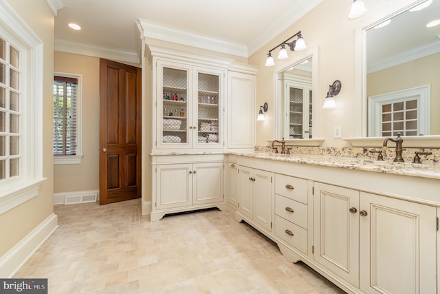 full bathroom featuring double vanity, visible vents, ornamental molding, and a sink