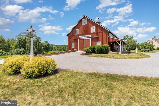 exterior space featuring a lawn, driveway, and a detached garage