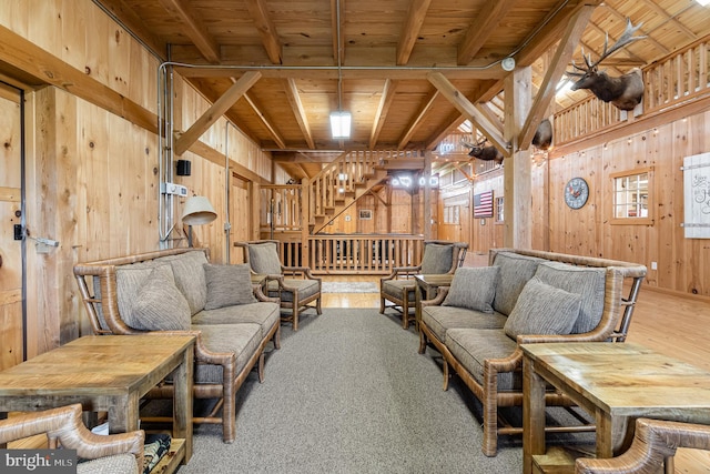 living area with wood finished floors, wooden ceiling, wooden walls, and stairs