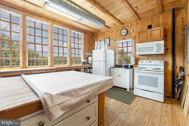 kitchen with white appliances, wood ceiling, beamed ceiling, wood walls, and light wood-style floors