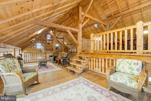 sitting room with wood ceiling, wood-type flooring, and lofted ceiling with beams