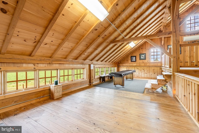 game room with lofted ceiling with beams, wood walls, wooden ceiling, and light wood finished floors