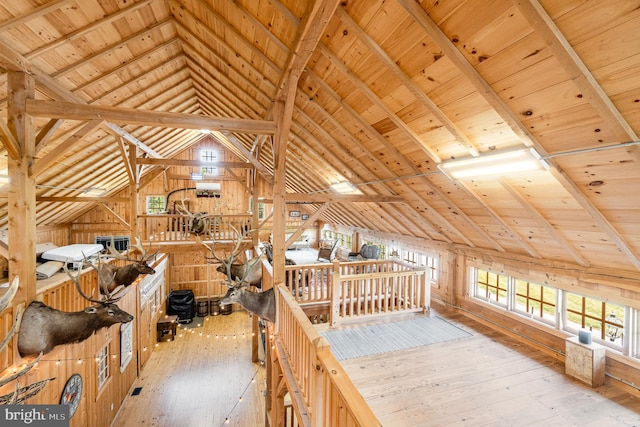 interior space featuring lofted ceiling with beams, light wood finished floors, and wood ceiling