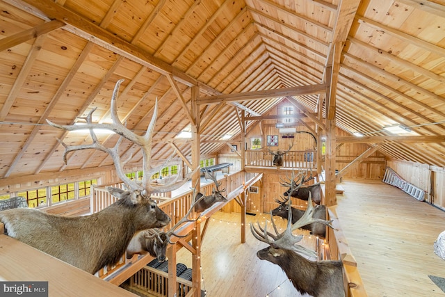 interior space featuring lofted ceiling with beams, hardwood / wood-style floors, wood ceiling, and wooden walls