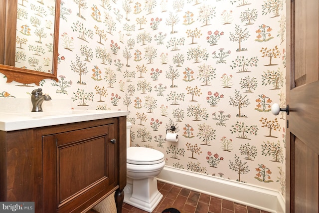 half bath featuring vanity, toilet, and wallpapered walls