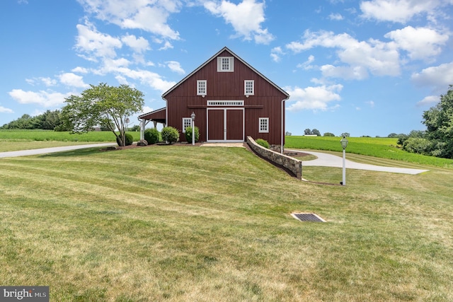 view of front facade featuring an outbuilding, a front yard, a barn, and a detached garage