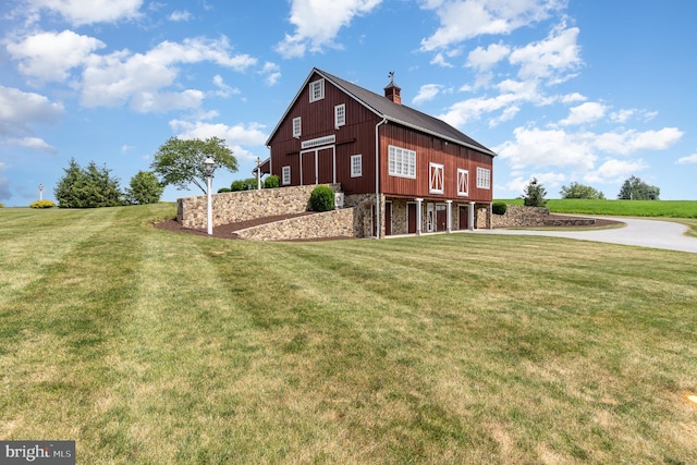 view of property exterior with stone siding, a chimney, and a yard