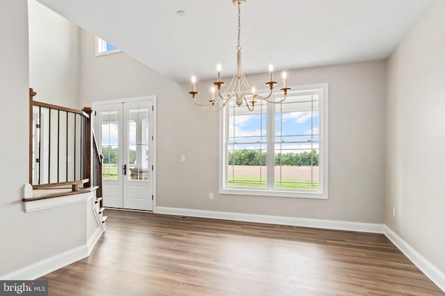 interior space featuring a chandelier, dark wood-style flooring, plenty of natural light, and baseboards