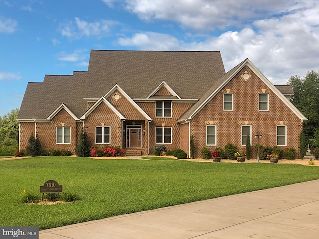 view of front of home with brick siding and a front yard