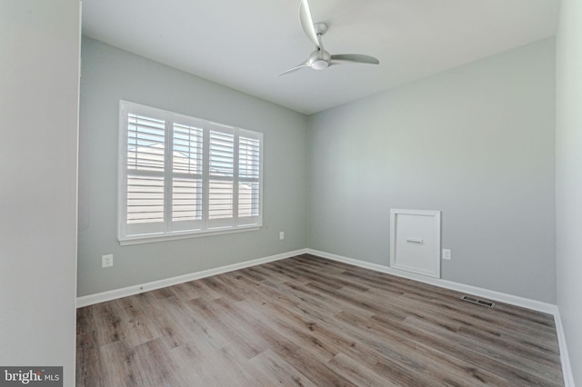 empty room featuring light wood-type flooring, a ceiling fan, and baseboards