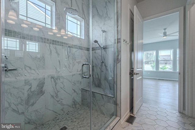 bathroom featuring baseboards, visible vents, plenty of natural light, and a marble finish shower