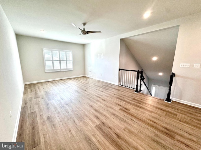 empty room with a ceiling fan, light wood-type flooring, and baseboards