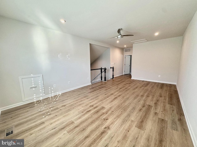 unfurnished room with a ceiling fan, visible vents, light wood-style flooring, and baseboards