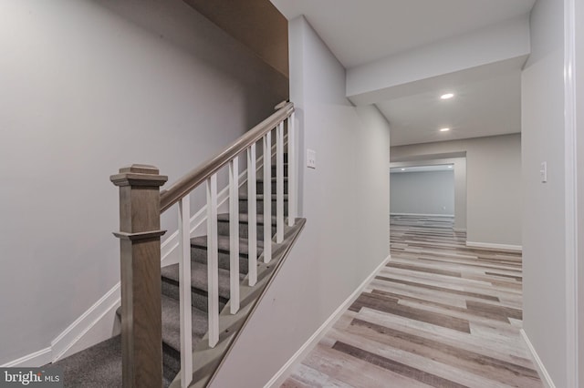 staircase with recessed lighting, baseboards, and wood finished floors