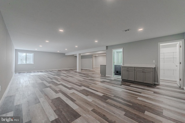 below grade area featuring light wood-style floors, recessed lighting, visible vents, and baseboards