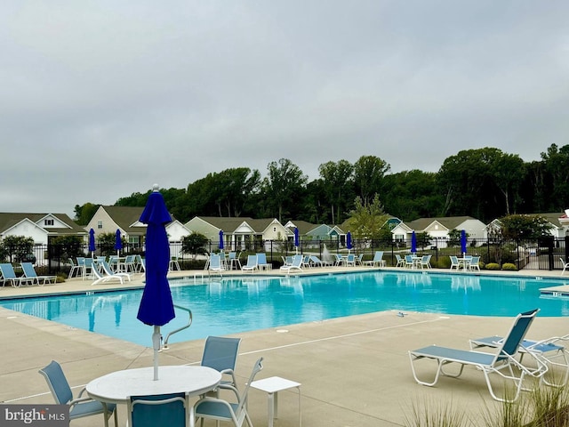 pool featuring fence and a patio