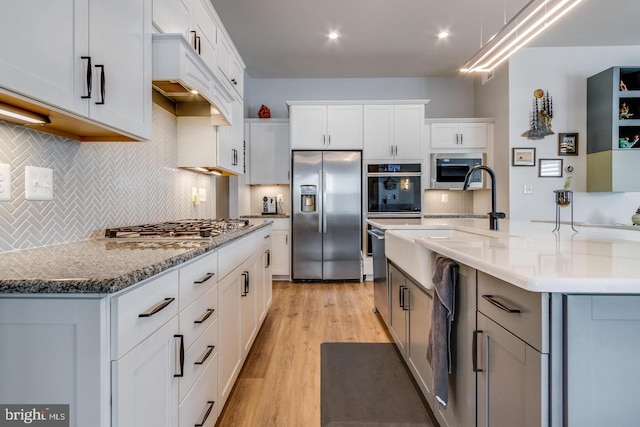 kitchen featuring white cabinets, a kitchen island with sink, and stainless steel appliances