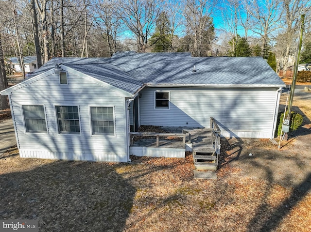 back of house with a shingled roof and a deck