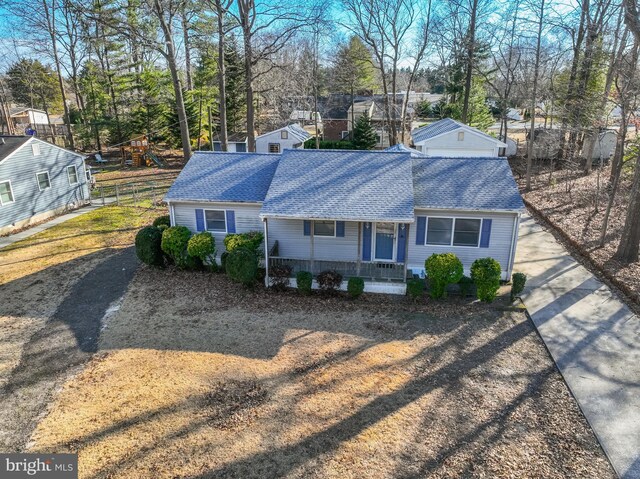 exterior space featuring fence, a porch, and roof with shingles