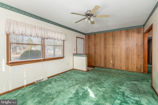 carpeted empty room featuring baseboards, visible vents, and ceiling fan