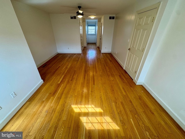 interior space with light wood-type flooring, visible vents, and baseboards