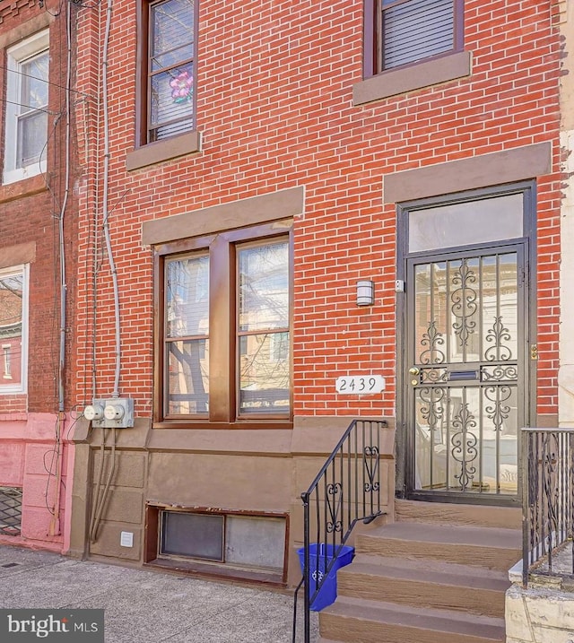 doorway to property with brick siding