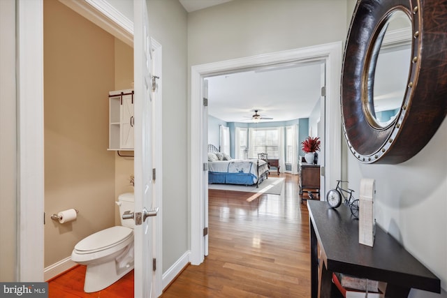 corridor with wood finished floors and baseboards