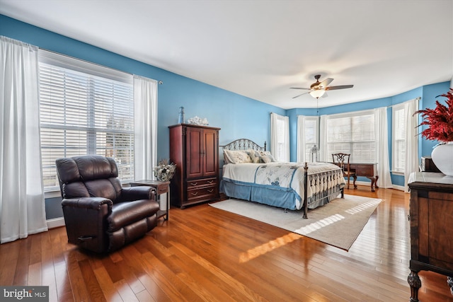 bedroom with baseboards, hardwood / wood-style flooring, and a ceiling fan