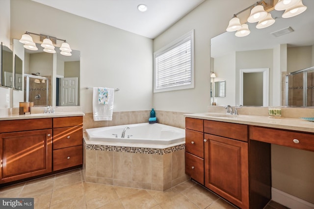 full bathroom featuring a stall shower, a garden tub, a sink, and tile patterned floors