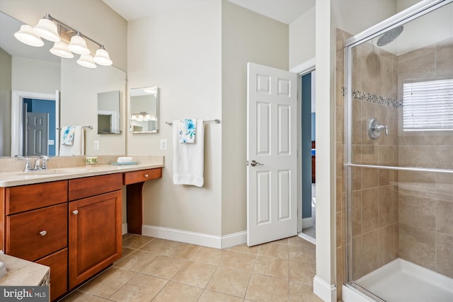 bathroom featuring baseboards, a shower stall, vanity, and tile patterned floors