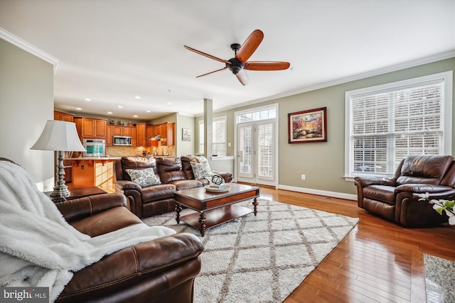 living area with recessed lighting, baseboards, crown molding, and light wood finished floors