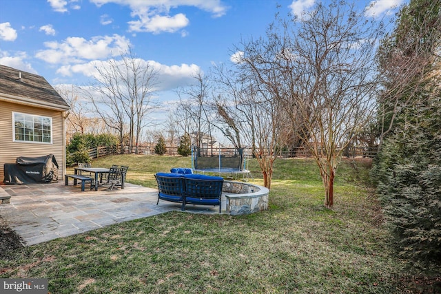 view of yard featuring a trampoline, a patio area, and a fenced backyard