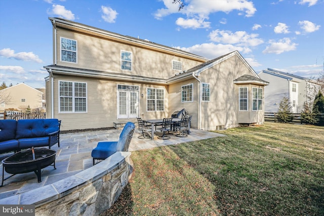 rear view of property featuring a yard, a patio area, fence, and a fire pit