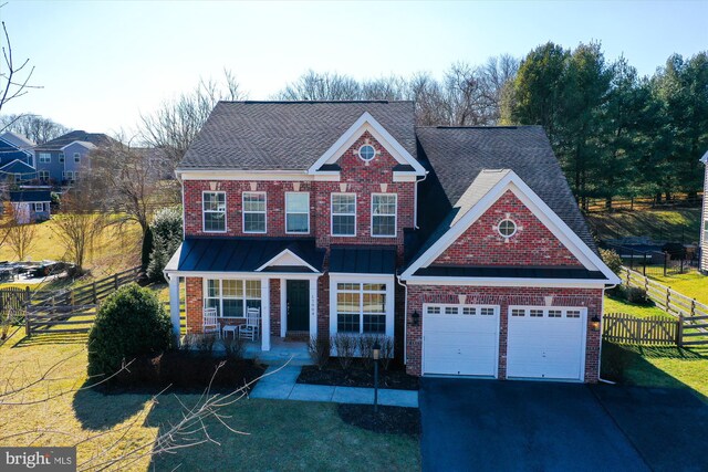 traditional home featuring brick siding, covered porch, a front yard, fence, and a garage