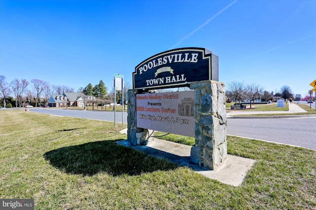 community / neighborhood sign with a yard