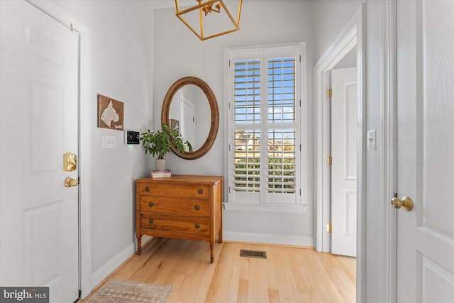 entrance foyer with visible vents, baseboards, and wood finished floors