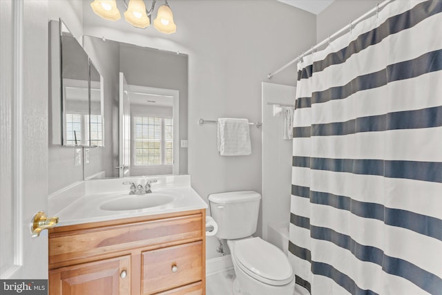 bathroom featuring a shower with shower curtain, vanity, toilet, and an inviting chandelier