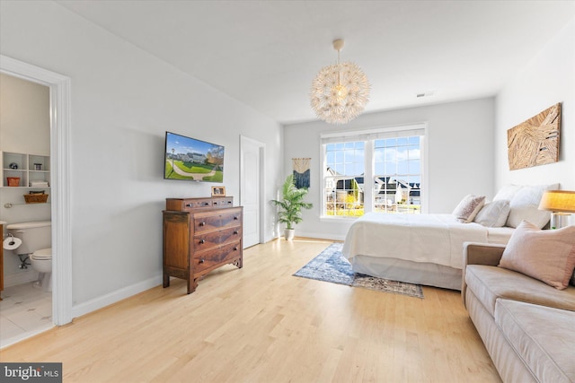 bedroom featuring light wood-type flooring, visible vents, baseboards, and an inviting chandelier