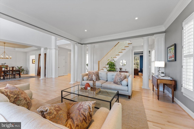 living area with decorative columns, a chandelier, and crown molding