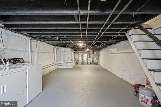 unfinished basement with water heater, washing machine and dryer, and stairs