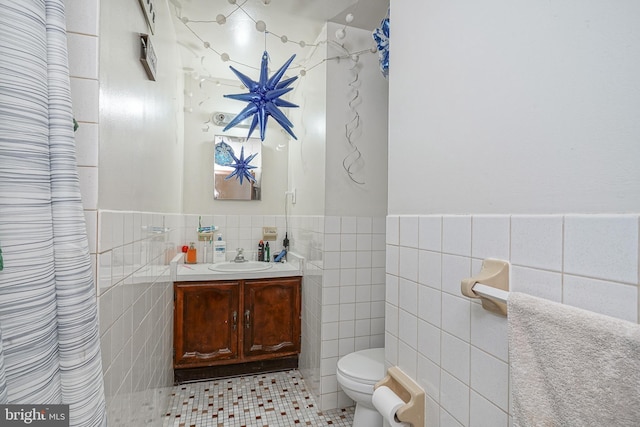 full bath with tile walls, toilet, and vanity